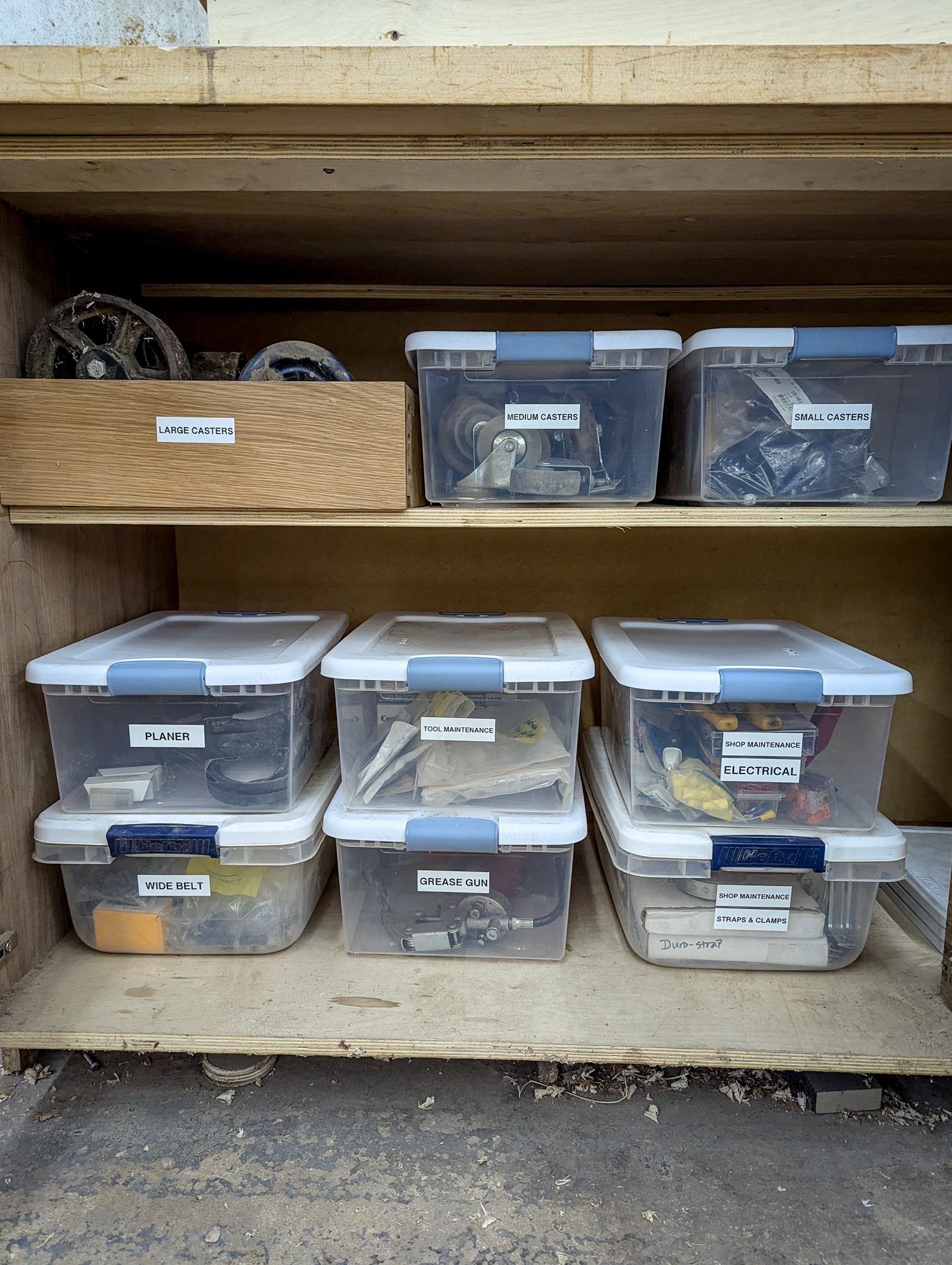 Labeled storage bins: castors, planer, electrical — East Point workshop
