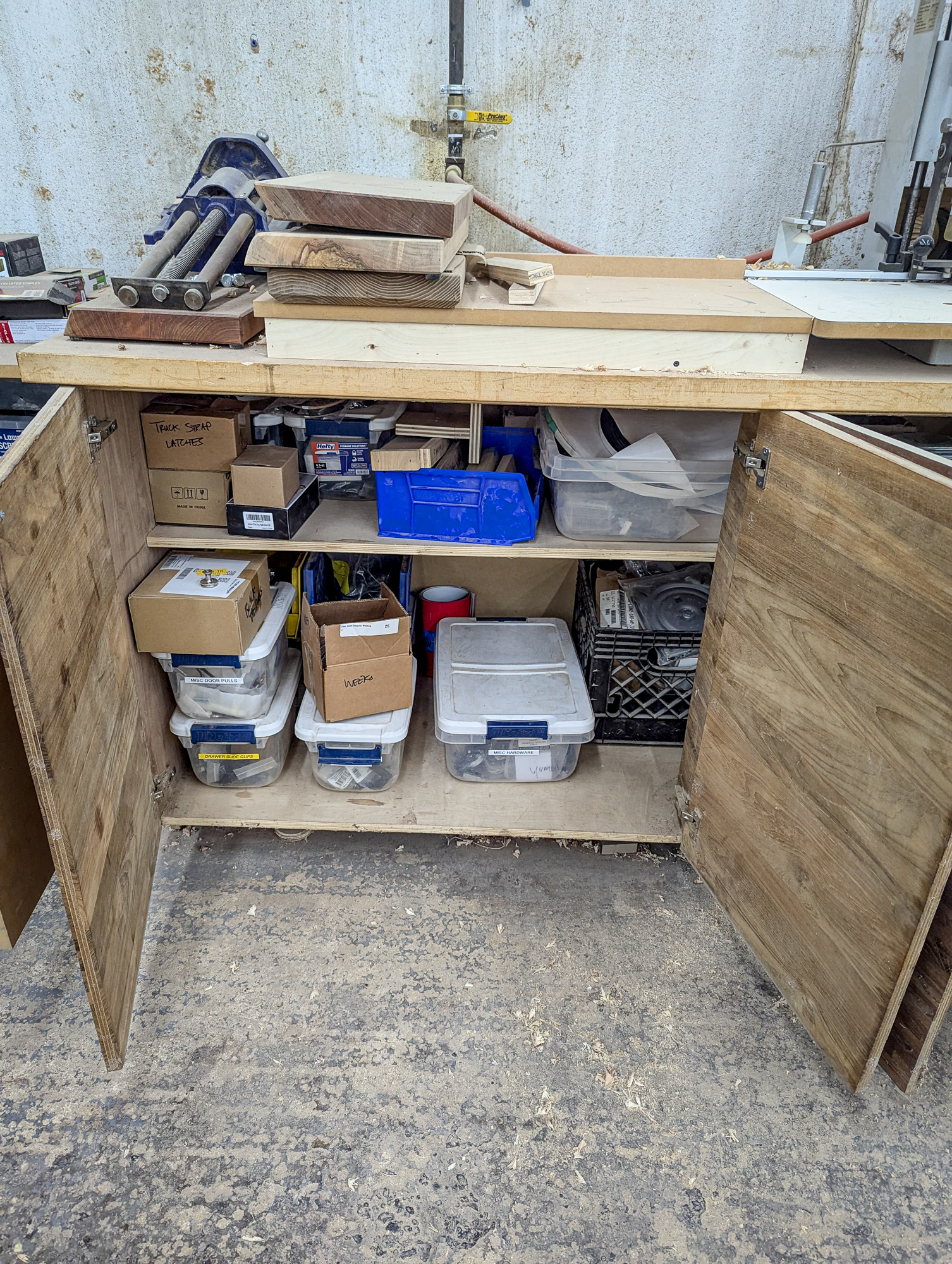 Disorganized workbench cabinet before organizing